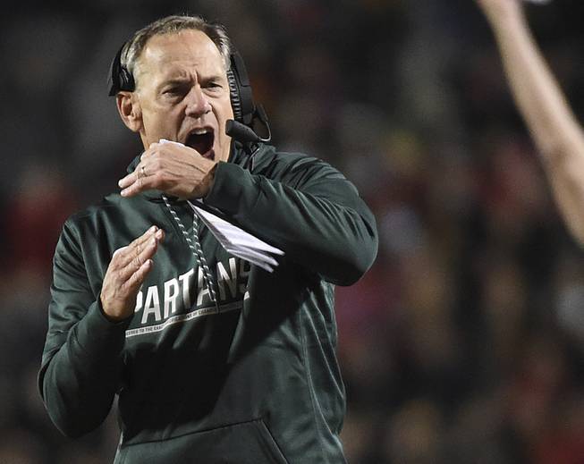 In this Oct. 22, 2016, file photo, Michigan State's Mark Dantonio calls for a timeout against Maryland in the first half of an NCAA college football game, in College Park, Md. Michigan State used to be at its best at the end of games, making plays on both sides of the ball and on special teams to win in the closing minutes or seconds. This year, the Spartans have been perhaps the worst team in major college football in the fourth quarter.