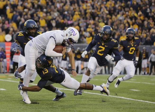 In this Saturday, Oct. 22, 2016, file photo, West Virginia cornerback Rasul Douglas (13) tackles TCU quarterback Kenny Hill (7) during the second half of an NCAA college football game, in Morgantown, W.Va. Defensive-minded West Virginia and Baylor will try this week to remain the Big 12's only undefeated teams.