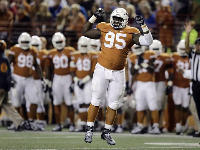 Texas defensive tackle Poona Ford (95) celebrates after he sacked Kansas quarterback Ryan Willis for a loss during the first half of an NCAA college football game, Saturday, Nov. 7, 2015, in Austin, Texas. 