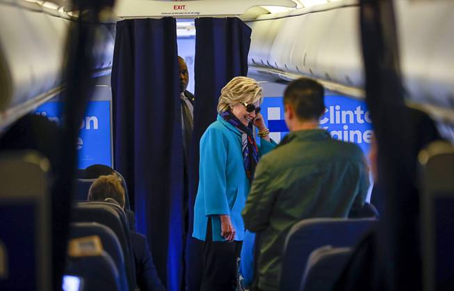 Hillary Clinton talks to staff after boarding her campaign plane, bound for a rally in Florida, on Saturday at the airport in White Plains, N.Y.