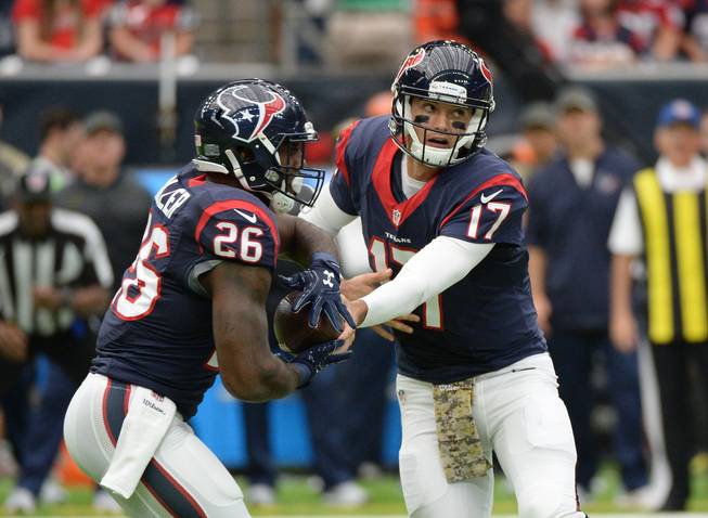 Houston Texans quarterback Brock Osweiler, right, hands off to Lamar Miller on Sunday, October, 30, 2016, during the first half of an NFL game against the Detroit Lions in Houston.