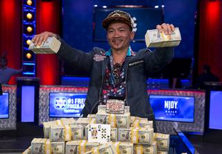 Qui Nguyen of Las Vegas holds up bundles of cash after defeating Gordon Vayo of San Francisco to win the World Series of Poker Main Event at the Rio Wednesday, Nov. 2, 2016.