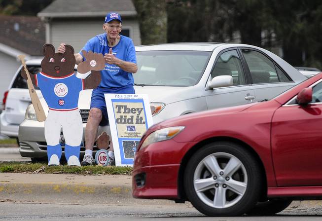Chicago Cubs fan Dan Wessel, 79, of Moline, Ill., gives a passing motorist the thumbs up Thursday morning, Nov. 3, 2016, after the driver honked in celebration of the Cubs winning the World Series. Wessel said he brought his homemade Cubs signs out to the corner of 16th Street and 31st Ave., in Moline, because he wanted to savor the moment of the Cubs winning the world championship. &quot;It's a once in a lifetime thing,&quot; said the die-hard Cubs fan.