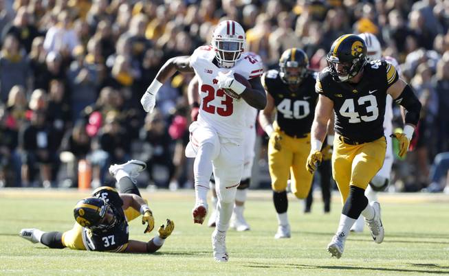 Wisconsin running back Dare Ogunbowale (23) runs from Iowa defenders Brandon Snyder (37) and Josey Jewell (43) during the first half of an NCAA college football game, Saturday, Oct. 22, 2016, in Iowa City, Iowa. 