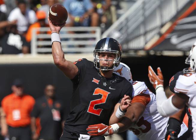In this Oct. 1, 2016, file photo, Oklahoma State quarterback Mason Rudolph (2) throws as he is hit by Texas defensive tackle Paul Boyette Jr. (93) in the first quarter of an NCAA college football game in Stillwater, Okla. Rudolph is the third straight quarterback that No. 10 West Virginia will face who is averaging at least 320 passing yards per game.