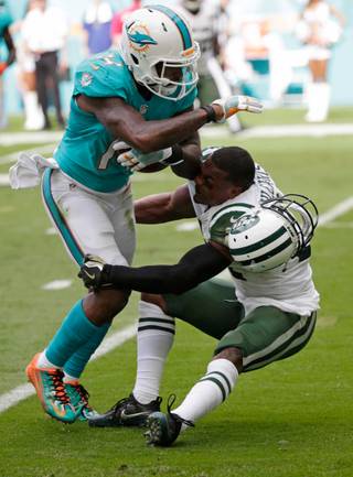 Miami Dolphins wide receiver Jarvis Landry (14) runs the ball as New York Jets free safety Marcus Gilchrist (21), attempts to make the tackle, during the first half of an NFL football game, Sunday, Nov. 6, 2016, in Miami Gardens, Fla. (AP Photo/Wilfredo Lee)