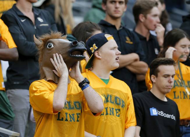 A Baylor fan wearing a horse mask and others react to a play against TCU in the first half of an NCAA college football game, Saturday, Nov. 5, 2016, in Waco, Texas.
