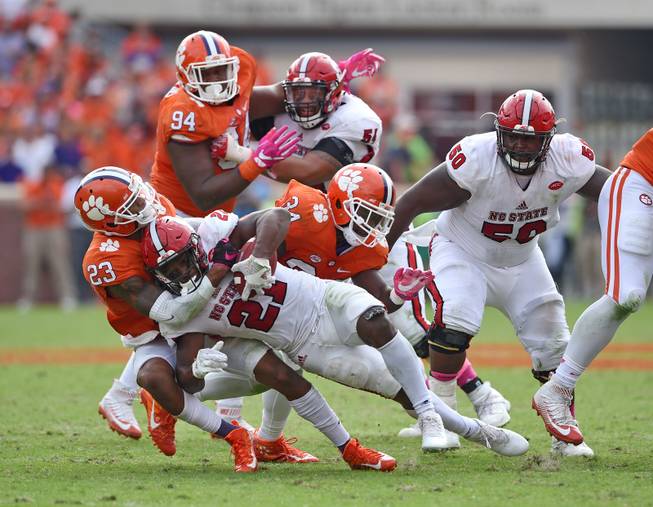 Clemson's Van Smith (21) and Kendall Joseph (34) tackle North Carolina State's Matthew Dayes during the second half of an NCAA college football game  Saturday, Oct. 15, 2016,  in Clemson,  S.C. Clemson won 24-17 in overtime.  