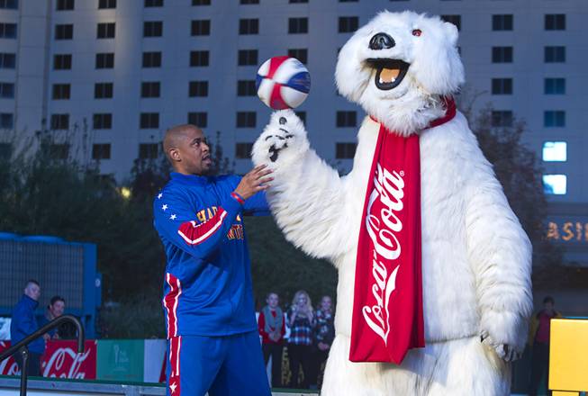 Scooter Christensen of the Harlem Globetrotters helps a Coca Cola bear spin a basketball on his claw during The Parks first-ever tree lighting ceremony in Toshiba Plaza Monday, Nov. 21, 2016. Christensen is an alumni of Bishop Gorman High School. The Globetrotters will perform in T-Mobile Arena on Feb. 9, 2017.