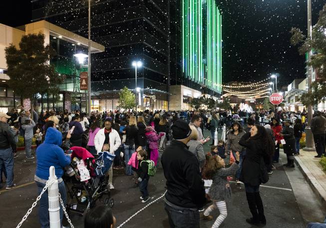 People enjoy the fake foam snow following the passing of the parade floats during the Downtown Summerlin Holiday Parade which included the tree lighting celebration, Friday, Nov. 18, 2016.