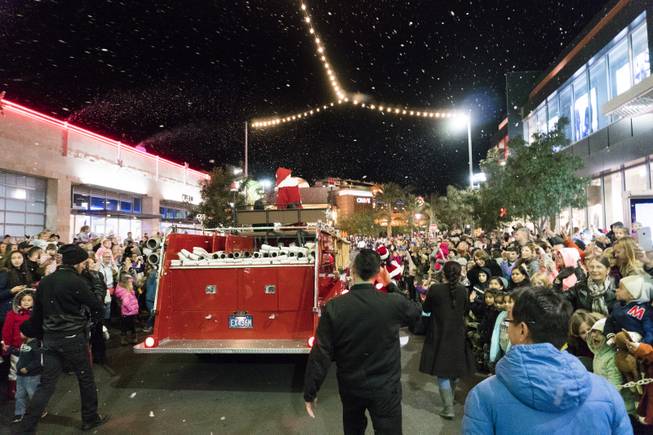 The crowd waves as a fire engine carrying Santa Claus passes by during the Downtown Summerlin Holiday Parade which included the tree lighting celebration, Friday, Nov. 18, 2016.