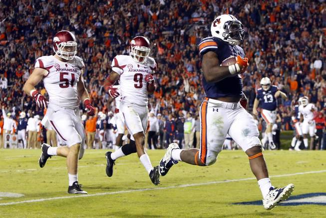  In this Oct. 22, 2016, file photo, Auburn running back Kamryn Pettway (36) scores a touchdown as he beats Arkansas linebacker Brooks Ellis (51) and defensive back Santos Ramirez (9) to the end zone during the second half of an NCAA college football game in Auburn, Ala. The status of Pettway, the No. 4 rusher in the nation, remains a mystery due to a left leg injury as the No. 8 Tigers try to protect their SEC title hopes in a game Saturday, Nov. 12, 2016, at Georgia. 