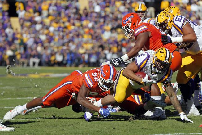LSU running back Derrius Guice (5) carries near the goal line as he is tackled by Florida defensive lineman Jabari Zuniga (92) in the first half an NCAA college football game in Baton Rouge, La., Saturday, Nov. 19, 2016. 