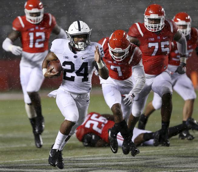 Penn State running back Miles Sanders (24) dashes from the Rutgers defense during the second half of an NCAA college football game Saturday, Nov. 19, 2016, in Piscataway, N.J. Penn State won 39-0. 
