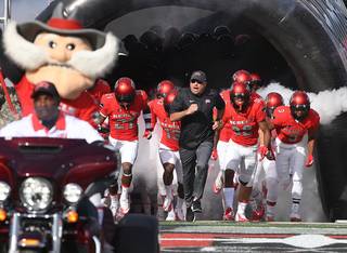 UNLV Rebels head coach Tony Sanchez leads the Rebels onto the field before taking on UNR at Sam Boyd Stadium today.