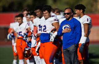 Bishop Gorman head coach Kenny Sanchez stands for the National Anthem with his team as they ready for their state semi-final game at Arbor View on Saturday, Nov. 26, 2016.