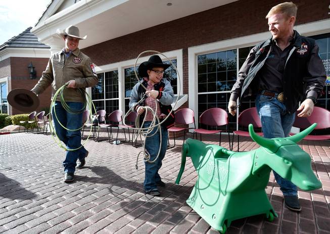 Quilan Bachlet, center, practices his roping skills with NFR cowboys Caleb Smidt, left, and Jacobs Crawley at Grant a Gift Autism Foundation at the UNLV Medicine Ackerman Autism Center Friday, Dec. 2, 2016, in Las Vegas.