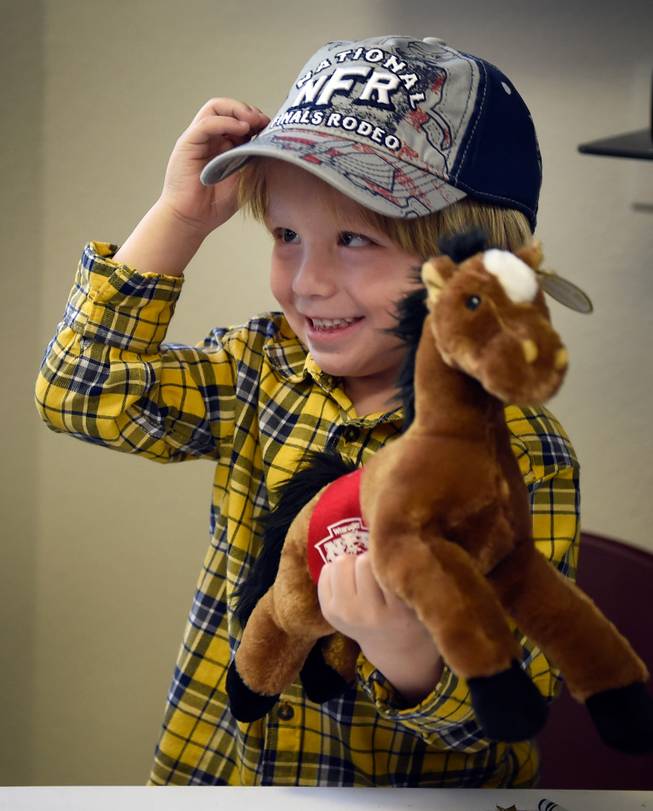 Tristan Duenez, 3, holds on to gifts he received from NFR cowboys during a visit to the Grant at Gift Autism Foundation at the UNLV Medicine Ackerman Autism Center Friday, Dec. 2, 2016, in Las Vegas.