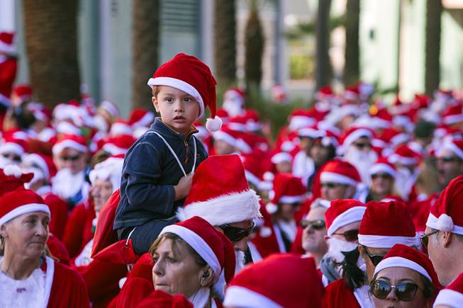 Peter Stanley, 4, sits on his father's shoulders as they wait for the start of the 12th annual Las Vegas Great Santa Run in downtown Las Vegas Saturday, Dec. 3, 2016. The fundraiser supports Opportunity Village, a charitable organization that supports people with intellectual disabilities.