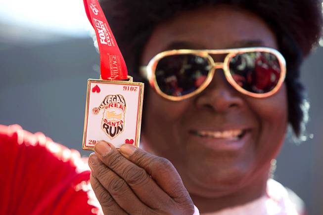 Entertainer Larry Edwards shows off his medal after running in the 12th annual Las Vegas Great Santa Run in downtown Las Vegas Saturday, Dec. 3, 2016. The fundraiser supports Opportunity Village, a charitable organization that supports people with intellectual disabilities.