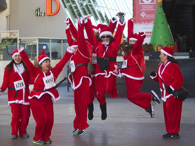 Victoria Agtonton, center, and other runners form the Las Vegas Athletic Club jump for a photo during the 12th annual Las Vegas Great Santa Run in downtown Las Vegas Saturday, Dec. 3, 2016. The runners were sponsored by the Venetian, they said. The fundraiser supports Opportunity Village, a charitable organization that supports people with intellectual disabilities.