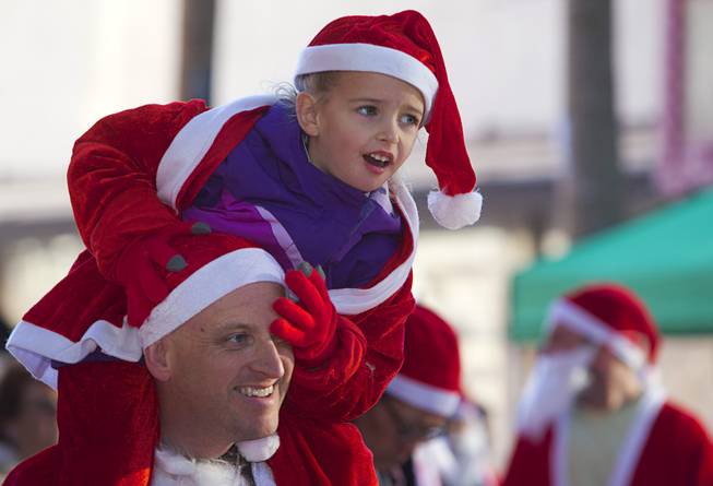 Gabriella Thiriot, 5, watches entertainers from her father's shoulders during the 12th annual Las Vegas Great Santa Run in downtown Las Vegas Saturday, Dec. 3, 2016. The fundraiser supports Opportunity Village, a charitable organization that supports people with intellectual disabilities.