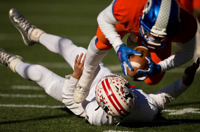 Bishop Gorman's Austin Arnold (6) snatches up a loose ball over Liberty QB Kenyon Oblad (7) for a score during their high school football state championship game at Sam Boyd Stadium on Saturday, Dec. 3, 2016.