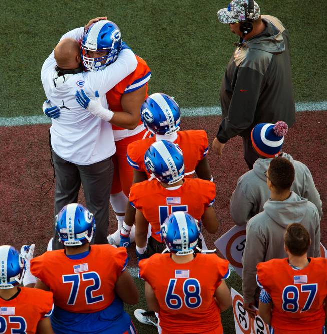 Bishop Gorman head coach Kenny Sanchez hugs a player leaving the field versus Liberty during their high school football state championship game at Sam Boyd Stadium on Saturday, Dec. 3, 2016.