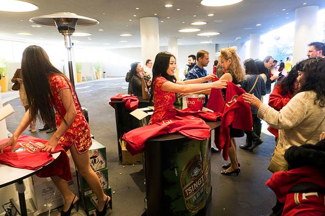 Guests get complimentary Tsingtao beer and t-shirts during Lucky Dragons grand opening celebration, Saturday, Dec. 3, 2016.