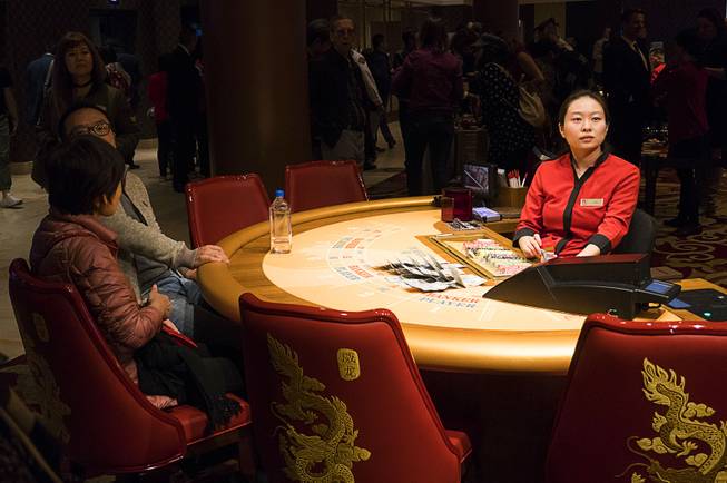 Gambler exchange money at a table game during Lucky Dragons grand opening celebration, Saturday, Dec. 3, 2016.