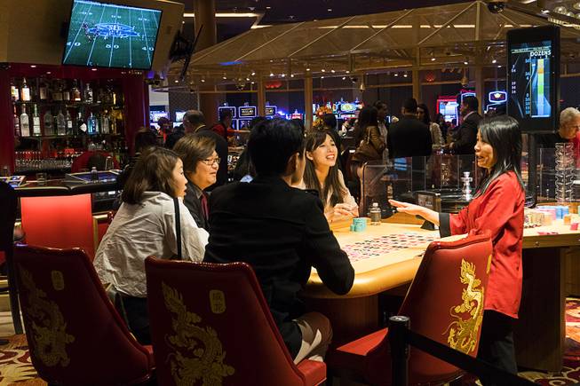 A roulette dealer talks to gamblers during Lucky Dragon's grand opening celebration, Saturday, Dec. 3, 2016.