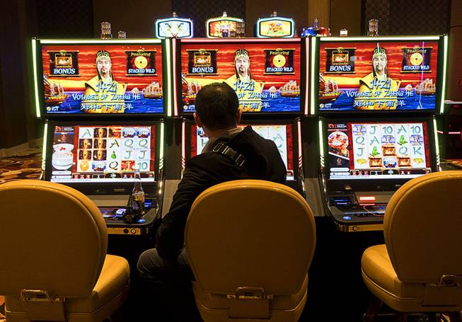 A guest plays a slot machine during Lucky Dragon's grand opening celebration, Saturday, Dec. 3, 2016.