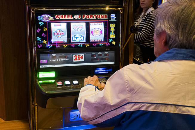 A gambler plays a Wheel of Fortune slot machine during Lucky Dragon's grand opening celebration, Saturday, Dec. 3, 2016.