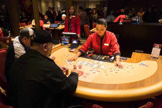 Gamblers play Ultimate Texas Holdem poker at Lucky Dragon during the boutique casinos grand opening celebration, Saturday, Dec. 3, 2016.