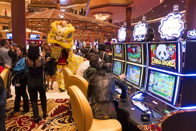 Lucky Dragon guests take photos with the dragon dancers during the boutique casino's grand opening celebration, Saturday, Dec. 3, 2016.