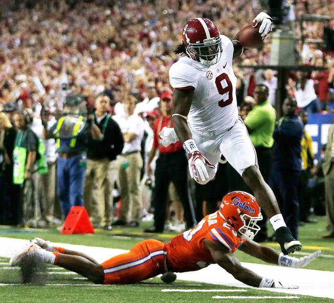 Alabama running back Bo Scarbrough, right, runs over Florida defensive back Chauncey Gardner during the second half of the Southeastern Conference championship NCAA college football game Saturday, Dec. 3, 2016, in Atlanta.
