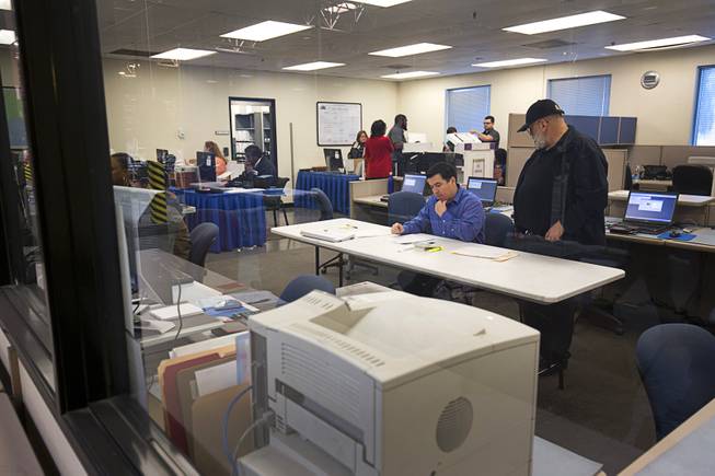 Charles Hurley, center, Clark County assistant registrar of voters, and Louis Gonzalez, right, a senior programmer analyst, help conduct an election recount of 84 precincts at a Clark County Election Department warehouse in North Las Vegas Monday, Dec. 5, 2016. The recount was requested and is being paid for by former presidential candidate Roque "Rocky" De La Fuente, a California businessman.