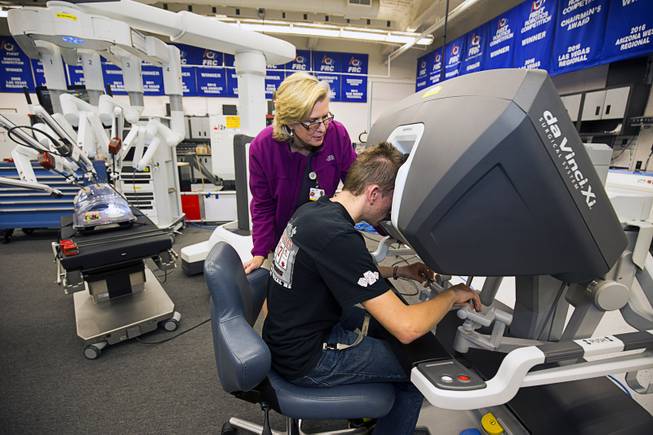 Eleanor Markle, MountainView Hospital robotic program manager, watches as student Damien Walker operates Intuitive Surgical's da Vinci Xi robotic surgical system at the Cimarron-Memorial High School engineering lab Tuesday, Dec. 6, 2016. MountainView Hospital and Intuitive Surgical, Inc. partnered in the event to teach students about careers in robotics, engineering and medicine.
