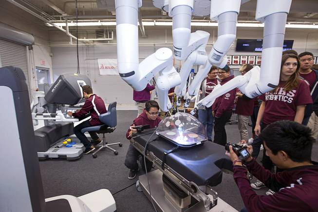 Students take video as another student, left, operates Intuitive Surgical's da Vinci Xi robotic surgical system at the Cimarron-Memorial High School engineering lab Tuesday, Dec. 6, 2016. MountainView Hospital and Intuitive Surgical, Inc. partnered in the event to teach students about careers in robotics, engineering and medicine.