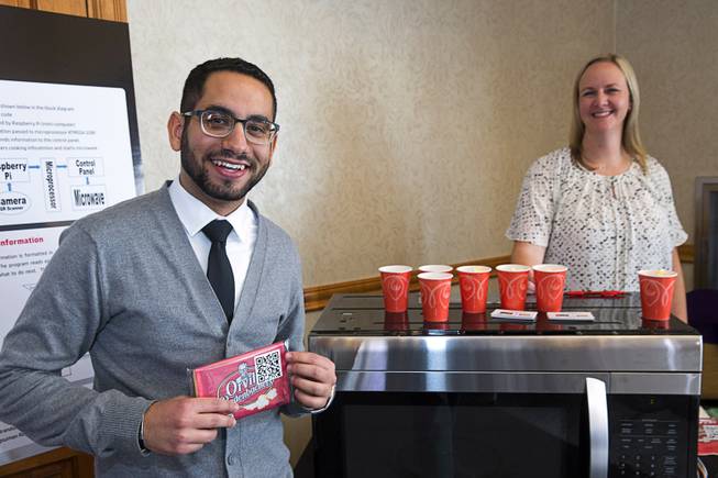 UNLV engineering students Youssel Abdallah and Alyson Weber show off their Smart Microwave during a UNLV Senior Design showcase at UNLV Wednesday, Dec. 7, 2016. The microwave reads QR codes on packages to cook at the ideal times and give instructions to consumers on how best to prepare the food. (Teammate Michelle Mata is not pictured)