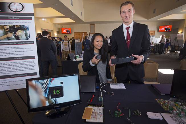 UNLV engineering students Nicole Manglicmot and Richard Garness show off a Tactical Smart Magz prototype system during a UNLV Senior Design showcase at UNLV Wednesday, Dec. 7, 2016. The Smart Magz keeps track of how many bullets are left in a magazine clip and displayed the information on a small mounted screen. (Not pictured are Alexander Smith and Rachel Suito-Acuna).