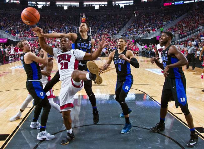 UNLV forward Christian Jones (20) takes a hard foul as Duke guard Frank Jackson (15) comes over his back during their game at the T-Mobile Arena on Saturday, Dec. 10, 2016.