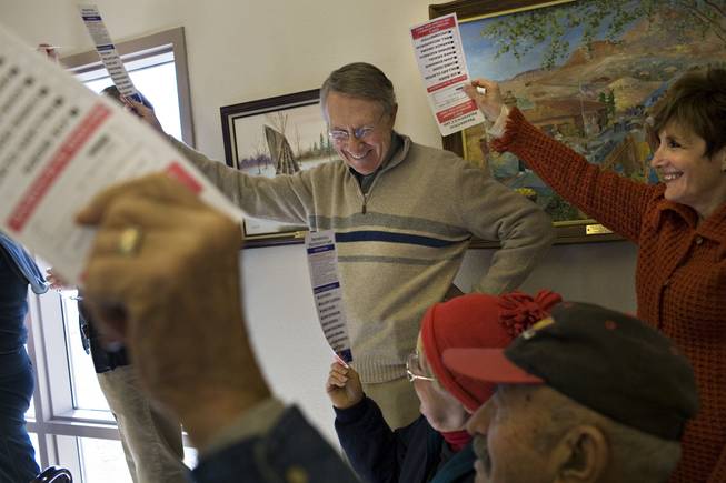 Reid and his wife, Landra Gould, raise their presidential preference cards to be counted at their home precinct in Searchlight, Nevada, for the 2008 democratic presidential caucus at the Searchlight Community Center.