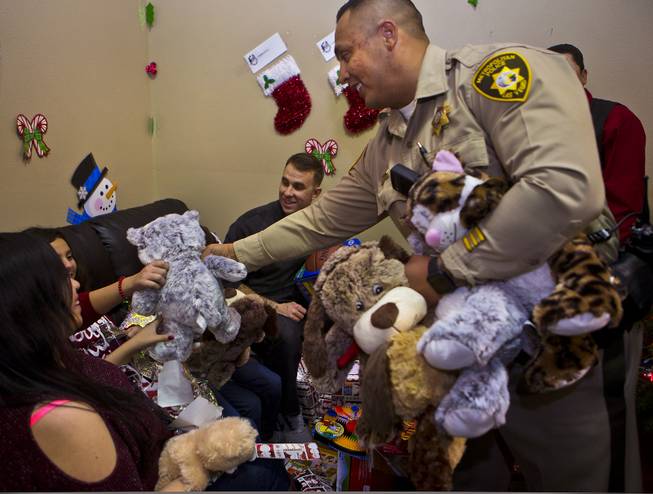 A Metro police officer  distributes stuffed animals during a Christmas party at Casa Grande Transitional Housing for children in the Las Vegas community who have parents who are incarcerated on Tuesday, Dec. 20, 2016.  It's a partnership between Hope for Prisoners and SOS Radio 90.5.