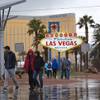 Tourists brave the rainy weather to take photos at the "Welcome to Las Vegas" sign Thursday, Dec. 22, 2016. 