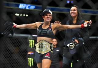 Women's bantamweight champion fighter Amanda Nunes continues to celebrate her quick win over Ronda Rousey in the octagon following their UFC 207 fight at the T-Mobile Arena on Friday, Dec. 30, 2016.  L.E. Baskow.