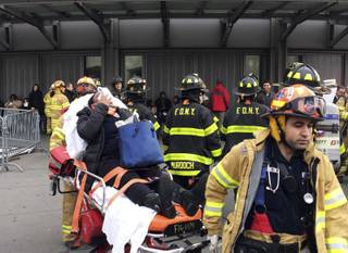 An injured passenger, after a Long Island Rail Road commuter train either hit something or derailed, is taken from the Atlantic Terminal, in the Brooklyn borough of New York, Wednesday, Jan. 4, 2017. (AP Photo/Mark Lennihan)
