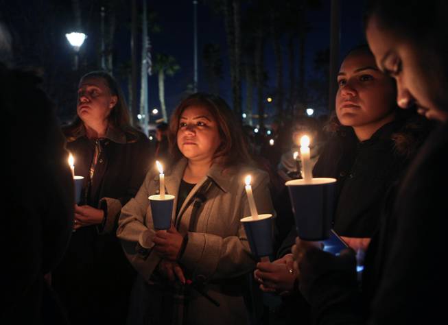 Mourners gather with lit candles during a candlelight vigil for North Las Vegas police detective or Chad Parque who died in a car crash on Sunday, Jan. 8, 2017.