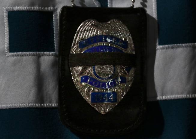 An officer's badge sports a black band during a candlelight vigil takes place for North Las Vegas police detective Chad Parque at the Clark County Community Resource Center parking lot where he was critically injured in a car crash and soon passed away on Sunday, Jan. 8, 2017.