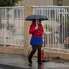 A woman walks along the sidewalk on Tropicana Avenue as rain continues to fall across the Las Vegas region on Friday, Jan. 13, 2017.